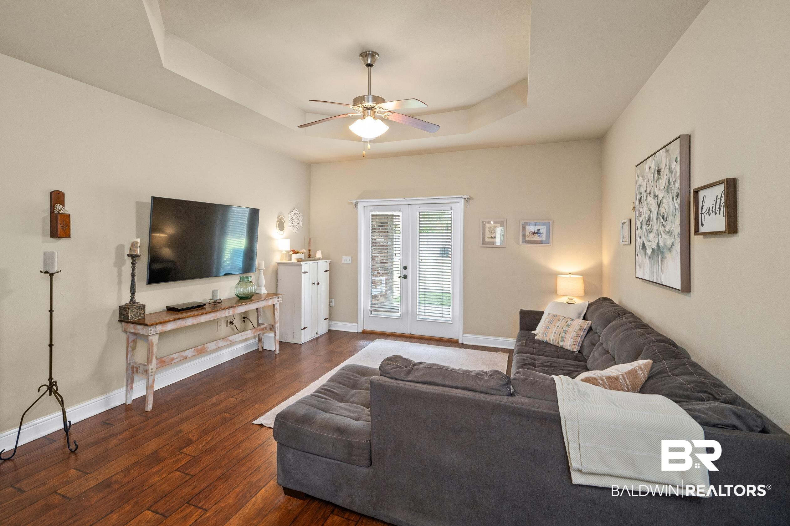 745 Bonaventure Street Fairhope, AL 36532 - Photo 5 of 36 Living room featuring a tray ceiling, dark hardwood / wood-style flooring, and ceiling fan