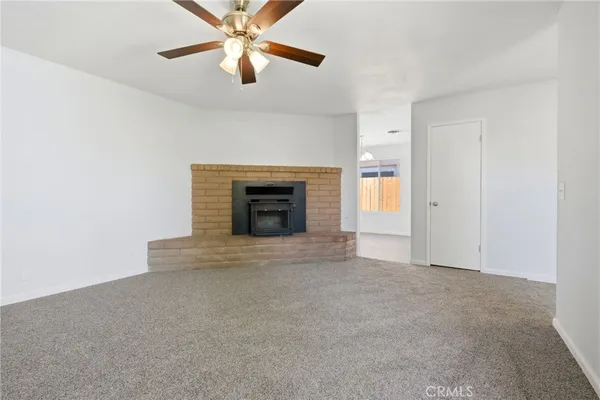 an empty room with fireplace and fan