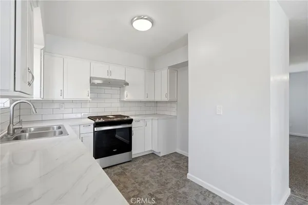 a kitchen with stainless steel appliances granite countertop a sink and a stove top oven