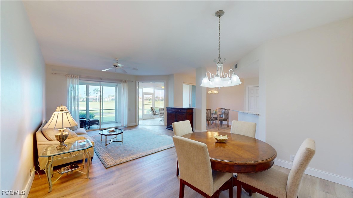 a dining room with furniture a chandelier and wooden floor