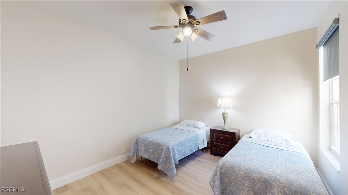 9130 Bayberry Bend, Unit 102 Fort Myers, FL 33908 - Photo 28 of 44 a bedroom with a bed chandelier and a window