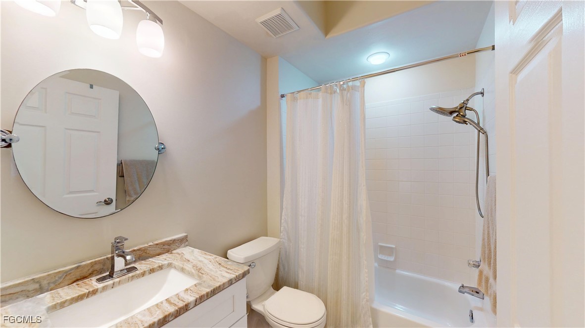 9130 Bayberry Bend, Unit 102 Fort Myers, FL 33908 - Photo 29 of 44 a bathroom with a granite countertop sink toilet and a mirror