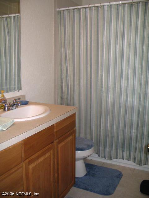 6142 Spring Hammock Road Jacksonville, FL 32226 - Photo 5 of 8 a bathroom with a sink a toilet a mirror and shower curtain