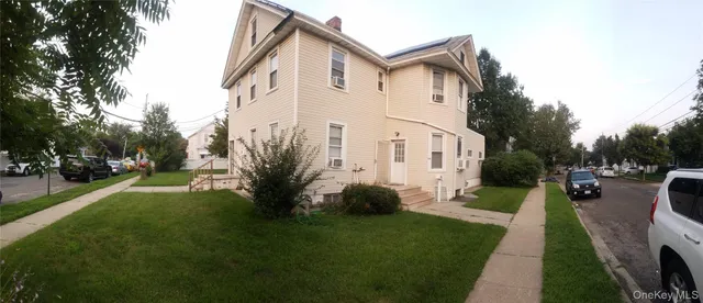 a front view of a house with a yard and trees