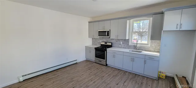 a kitchen with sink cabinets and wooden floor