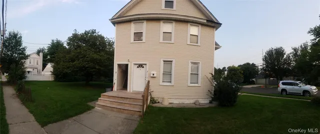 a view of a white house with a yard