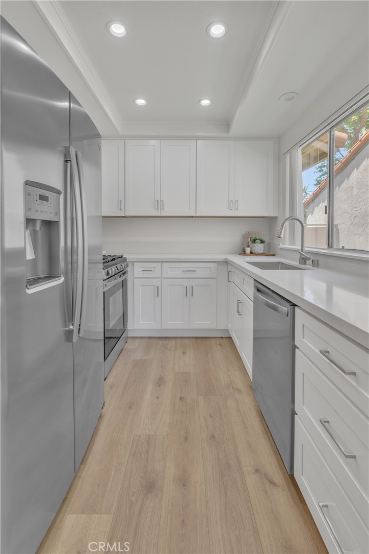 45 Orchard Irvine, CA 92618 - Photo 15 of 29 a kitchen with white cabinets stainless steel appliances and a window