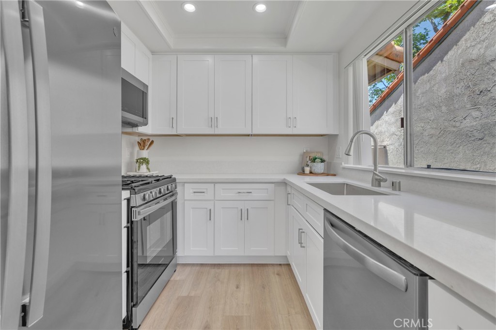 45 Orchard Irvine, CA 92618 - Photo 16 of 29 a kitchen with granite countertop a sink stove and refrigerator