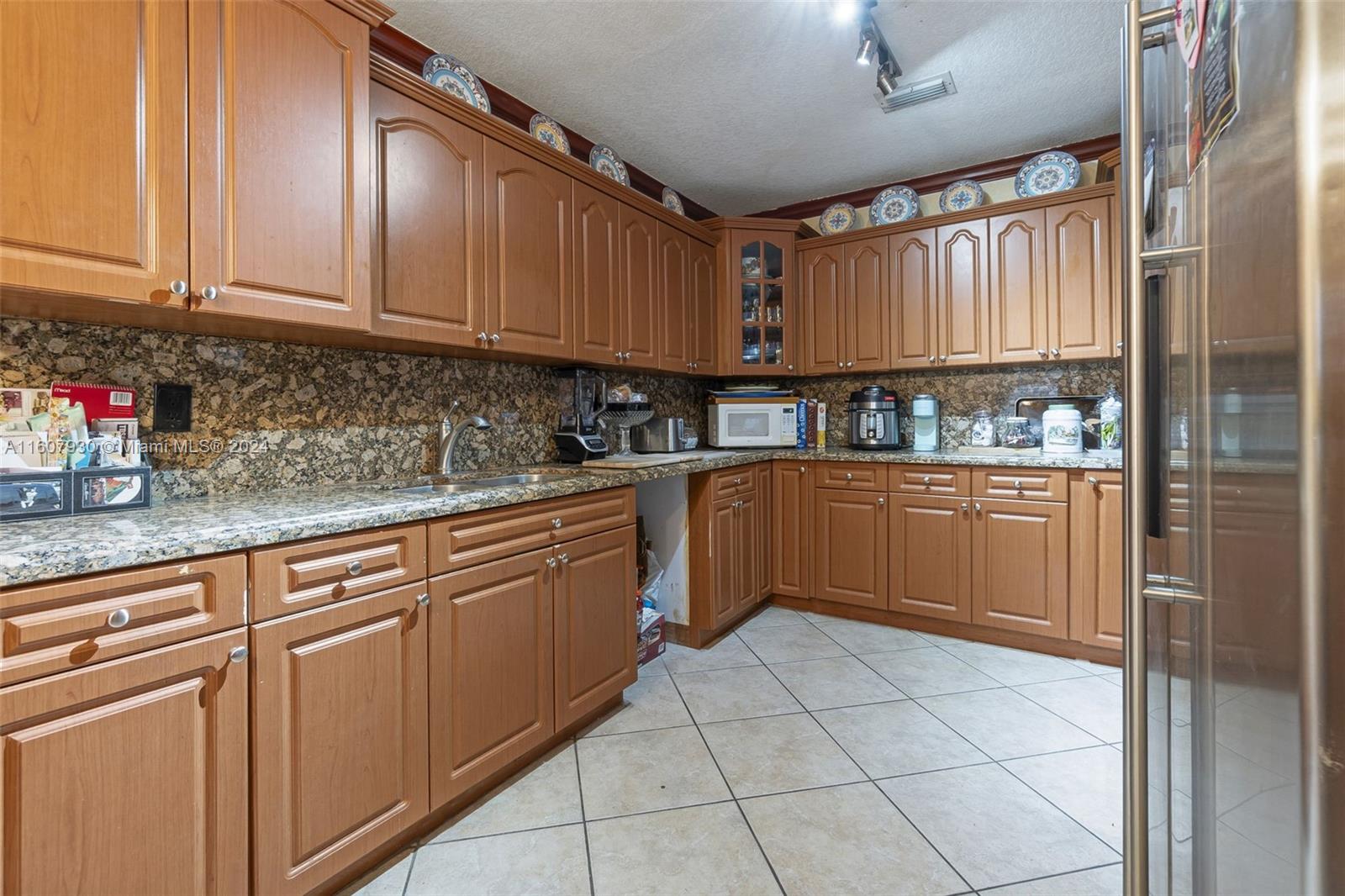 3015 Southwest 103rd Place Miami, FL 33165 - Photo 5 of 32 a kitchen with stainless steel appliances granite countertop a sink a stove cabinets and a counter top space