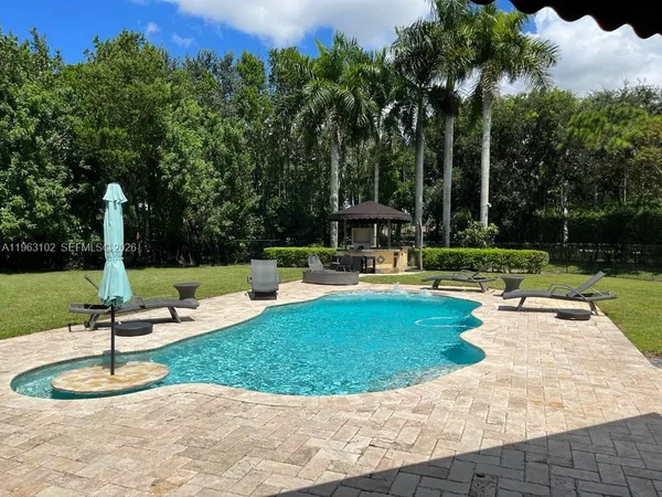 a view of a house with backyard and sitting area