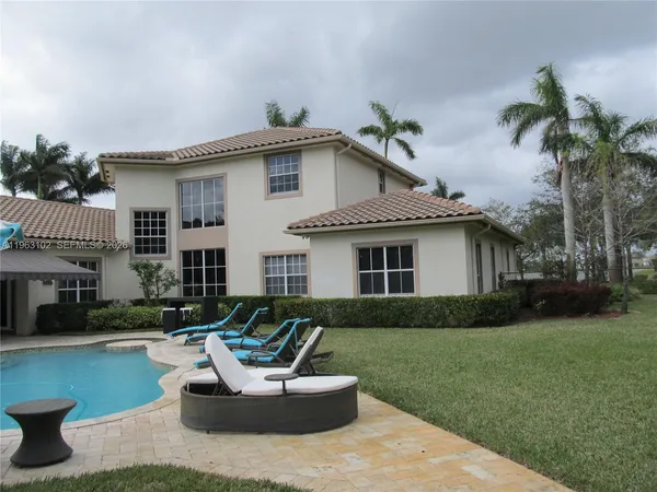 a view of a house with backyard and sitting area