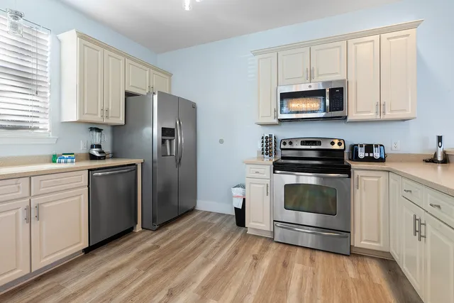 a kitchen with white cabinets and stainless steel appliances