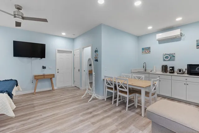 a living room with furniture a flat screen tv and kitchen view