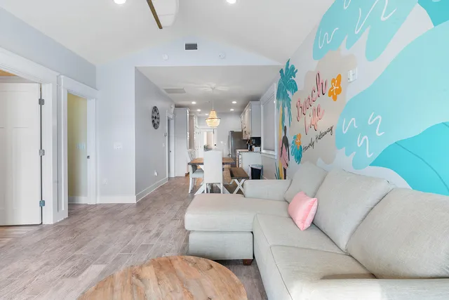 a large room with wooden floor pool table and chairs