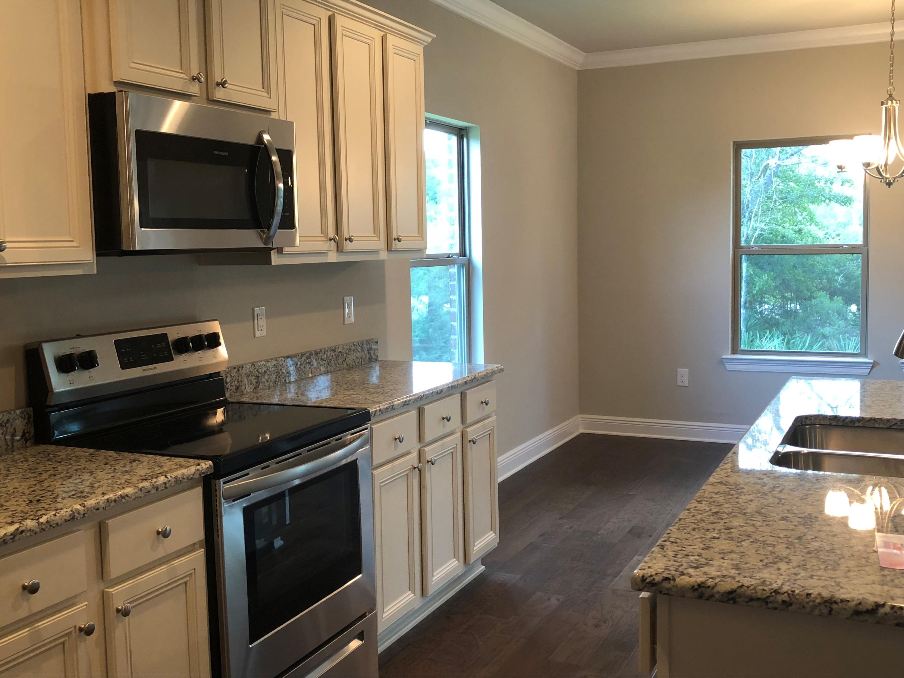 157 Wayne Trail Santa Rosa Beach, FL 32459 - Photo 5 of 17 a kitchen with stainless steel appliances granite countertop a stove a microwave and a sink
