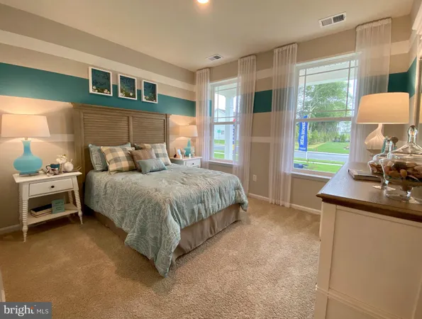 a bedroom with a bed and a dresser next to a window