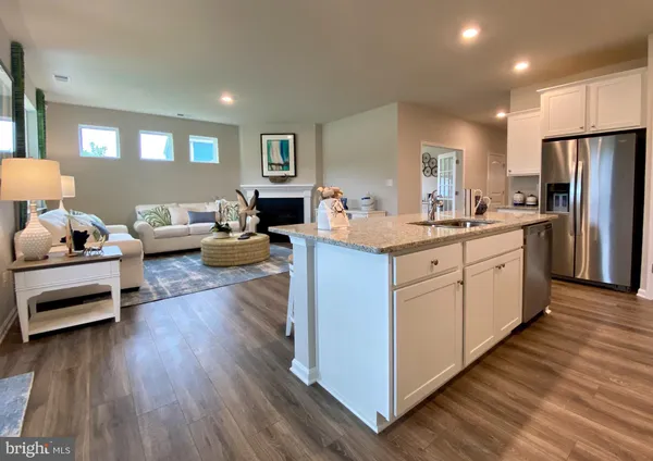 a kitchen with granite countertop a refrigerator sink and microwave