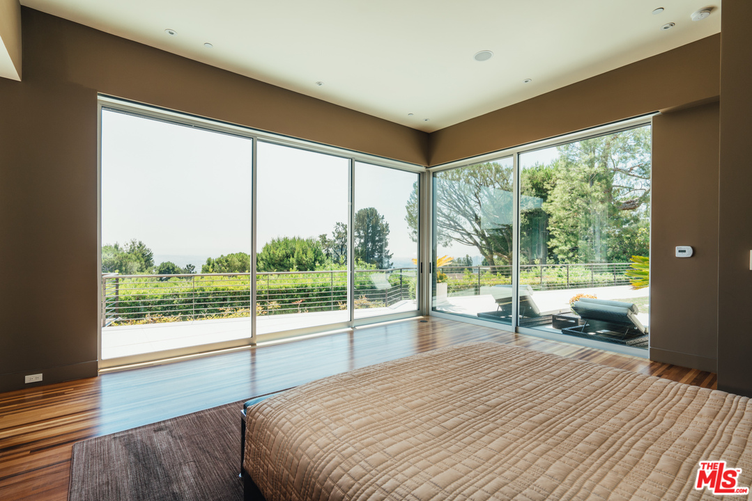 1470 Carla Ridge Beverly Hills, CA 90210 - Photo 14 of 44 a bedroom with a bed and glass door