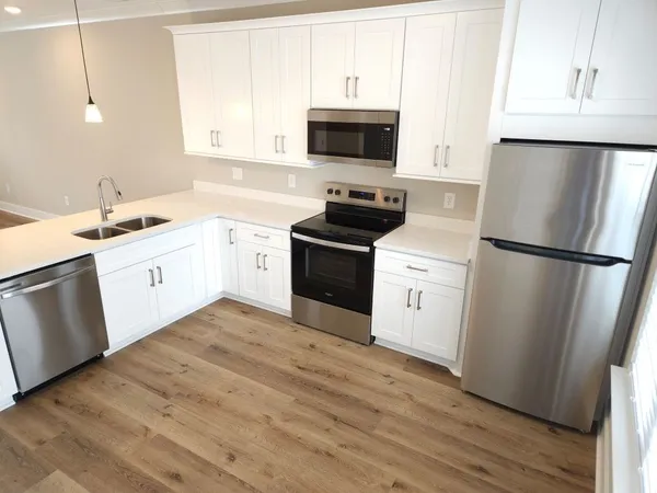 a kitchen with white cabinets and white appliances