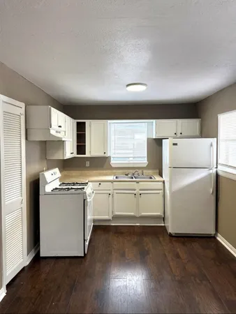 a kitchen with appliances a refrigerator and a stove top oven