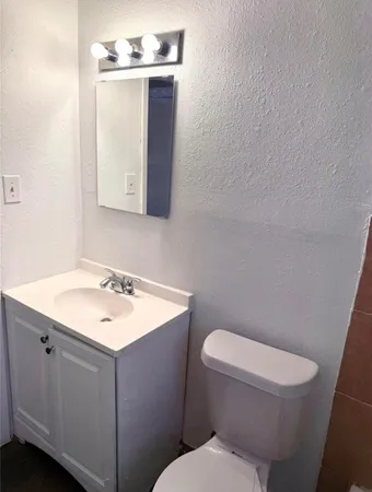a bathroom with a toilet a sink and mirror