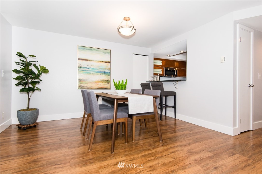 7323 Sand Point Way Northeast, Unit 106 Seattle, WA 98115 - Photo 12 of 21 a dining room with furniture potted plants and wooden floor