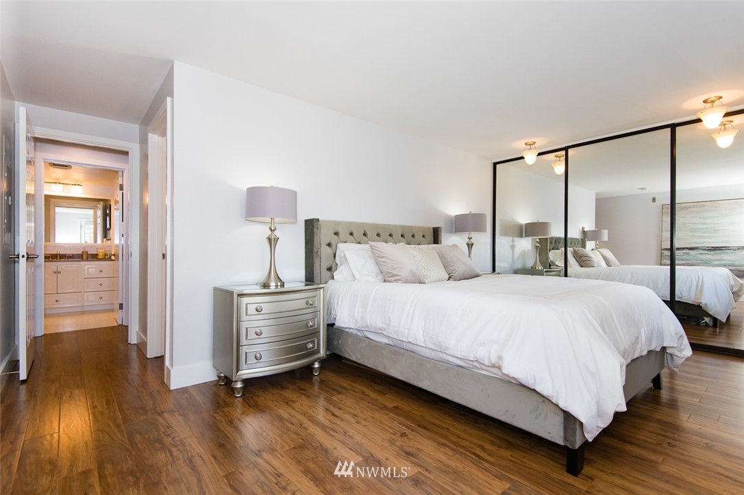 7323 Sand Point Way Northeast, Unit 106 Seattle, WA 98115 - Photo 16 of 21 a bedroom with a bed and wooden floor