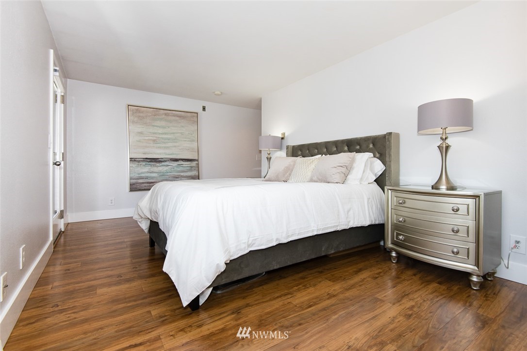7323 Sand Point Way Northeast, Unit 106 Seattle, WA 98115 - Photo 17 of 21 a bedroom with a bed and a night stand