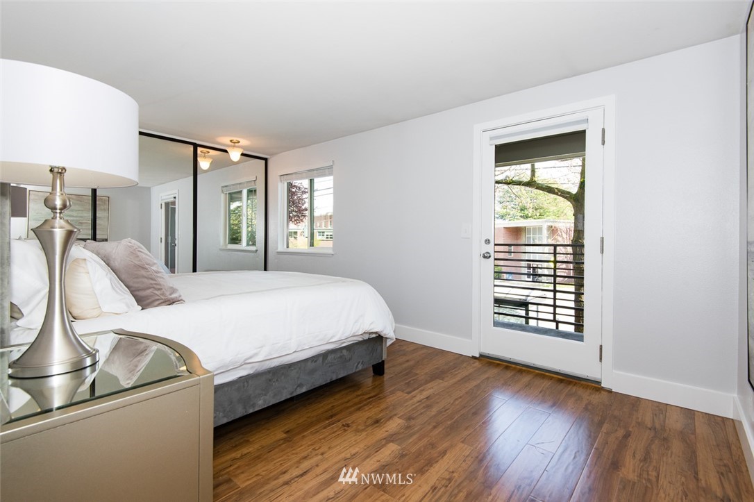 7323 Sand Point Way Northeast, Unit 106 Seattle, WA 98115 - Photo 18 of 21 a bed sitting in a spacious bedroom next to a window