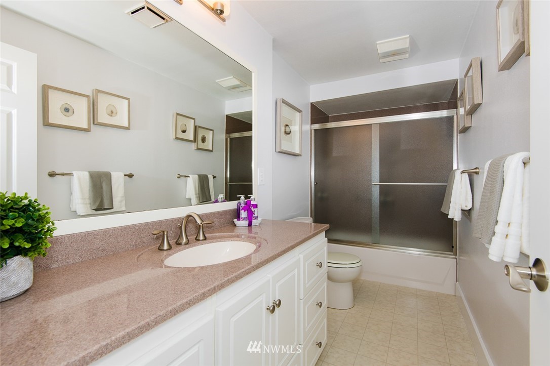 7323 Sand Point Way Northeast, Unit 106 Seattle, WA 98115 - Photo 19 of 21 a bathroom with a granite countertop sink toilet and shower
