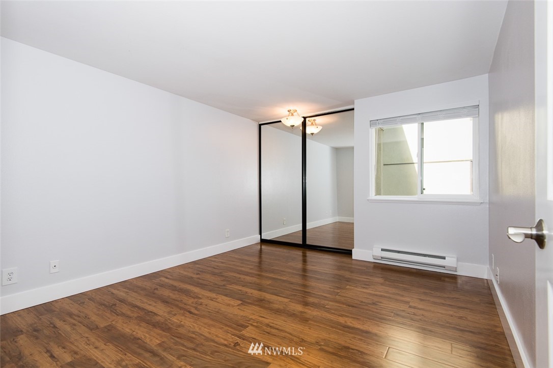 7323 Sand Point Way Northeast, Unit 106 Seattle, WA 98115 - Photo 20 of 21 an empty room with wooden floor and windows