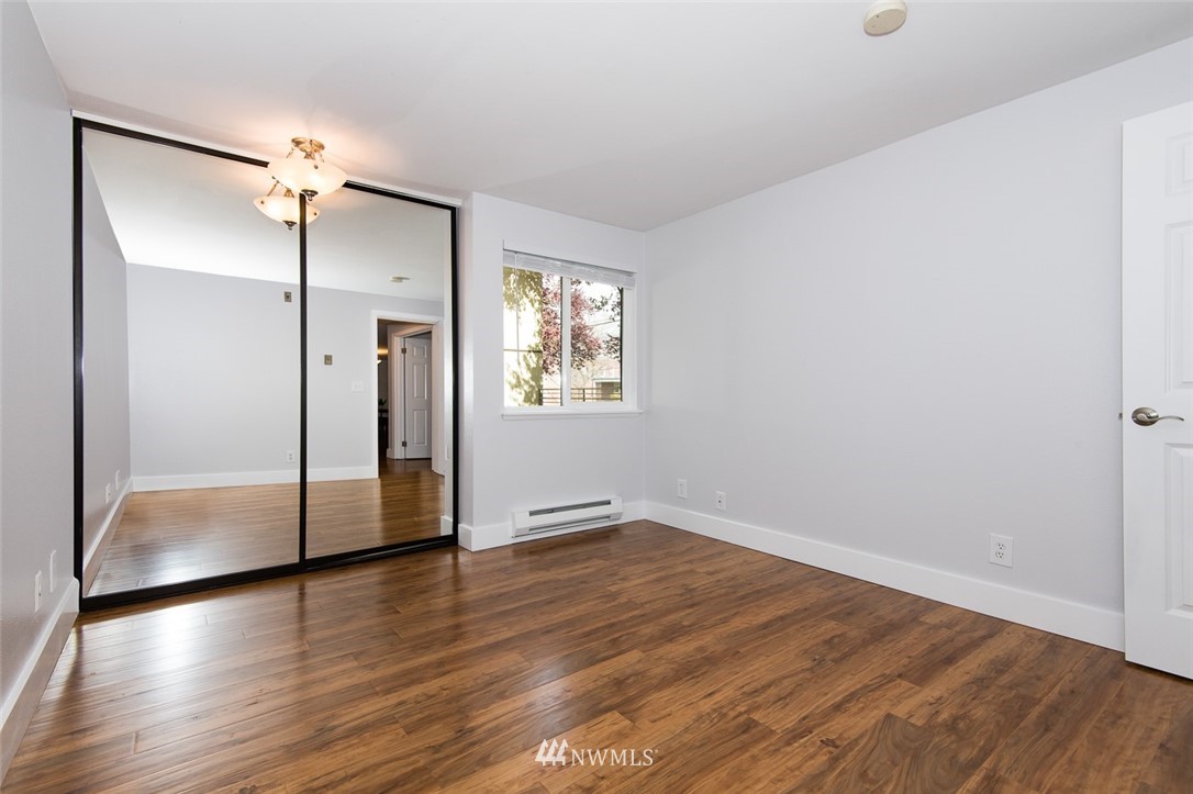7323 Sand Point Way Northeast, Unit 106 Seattle, WA 98115 - Photo 21 of 21 an empty room with wooden floor and a window