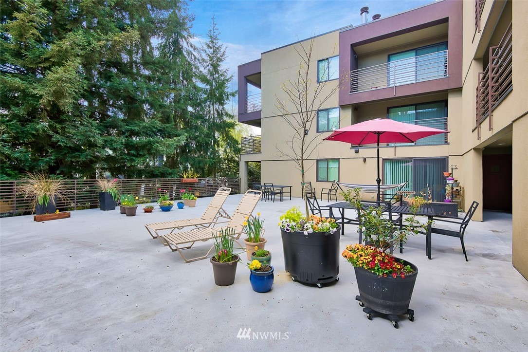 7323 Sand Point Way Northeast, Unit 106 Seattle, WA 98115 - Photo 4 of 21 a view of a chairs and tables in patio with a small yard