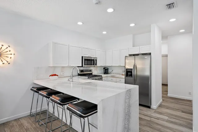 a kitchen with stainless steel appliances a stove a sink a refrigerator and cabinets