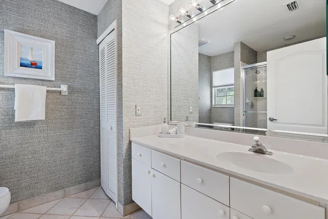 a bathroom with a double vanity sink a toilet and a mirror