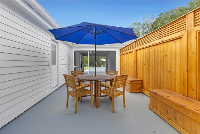a view of a patio with a table and chairs under an umbrella