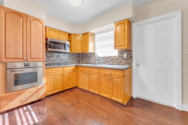 a kitchen with stainless steel appliances granite countertop a stove a sink and a microwave