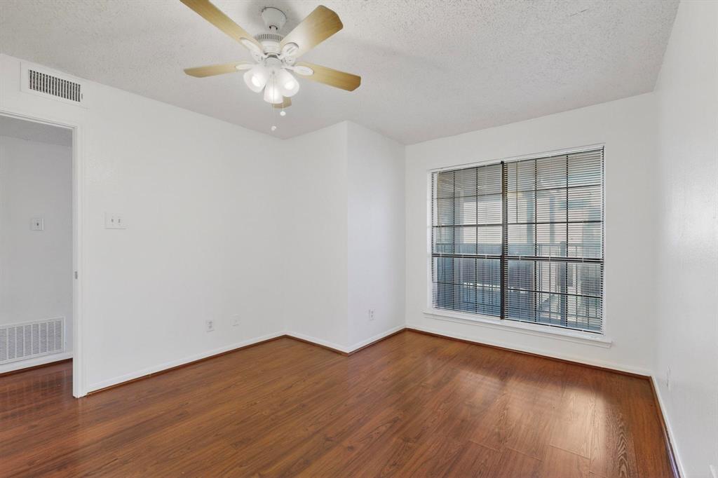 8545 Midpark Road, Unit 16 Dallas, TX 75240 - Photo 8 of 29 Unfurnished room featuring a textured ceiling, a ceiling fan, and dark wood-type flooring