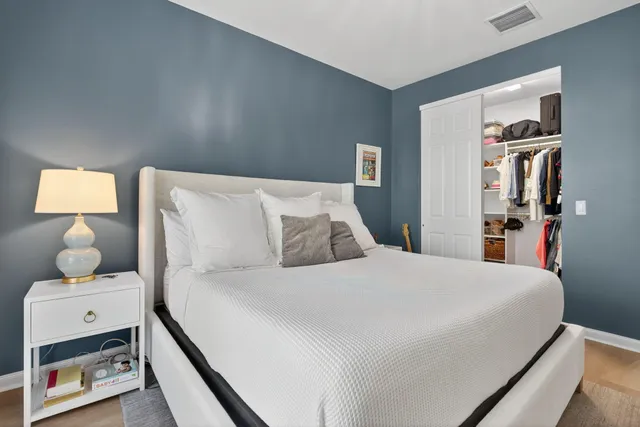 a bedroom with a bed and large windows