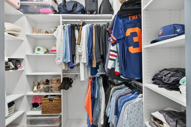 a bedroom with a bed and a lamp on dresser
