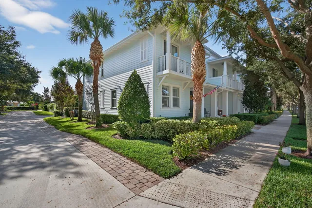 a front view of a house with garden and trees