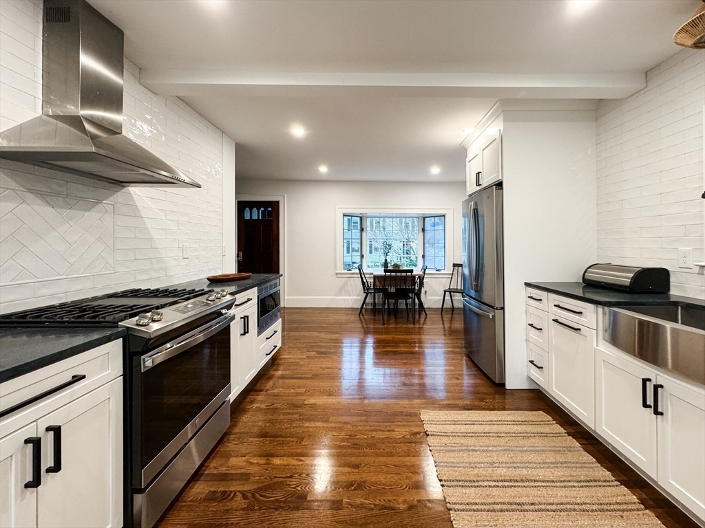 131 Damon Road Medford, MA 02155 - Photo 4 of 22 a kitchen with stainless steel appliances granite countertop a stove top oven a sink dishwasher and cabinets with wooden floor