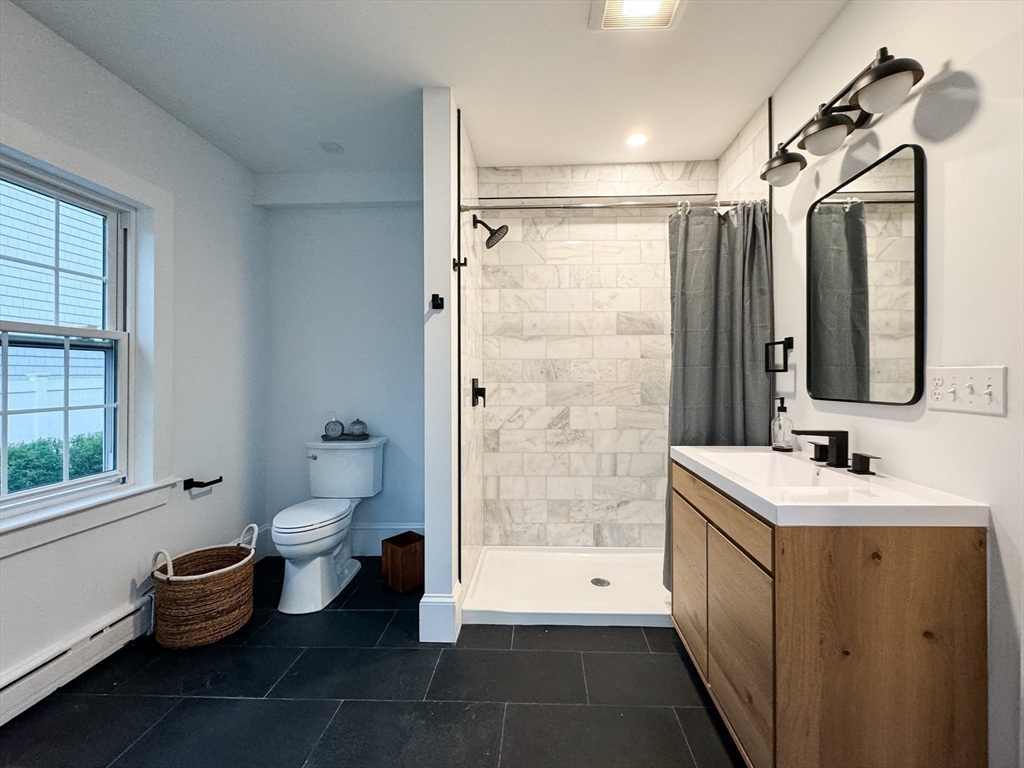 131 Damon Road Medford, MA 02155 - Photo 9 of 22 a bathroom with a toilet sink and a mirror