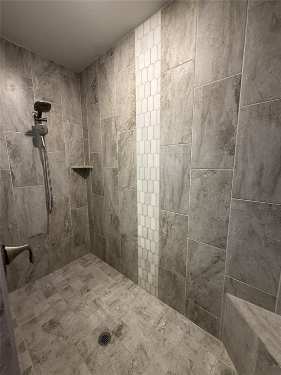 1049 Sarah Street Allen, TX 75013 - Photo 10 of 12 Tile shower featuring large format grey wall tiles with a decorative vertical accent stripe of white picket tile