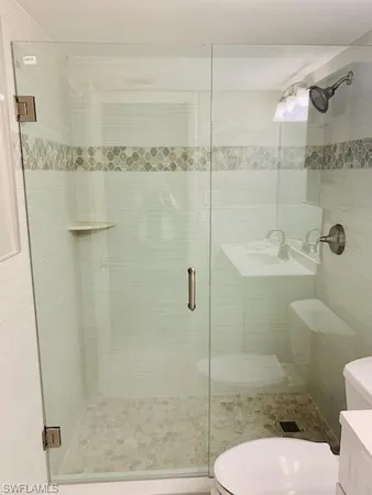 a bathroom with a shower a toilet and a sink
