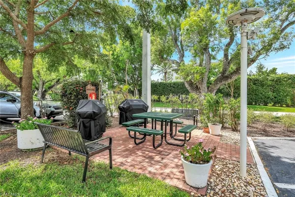 a view of a patio with table and chairs potted plants with large tree