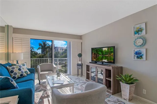a living room with furniture a flat screen tv and a large window