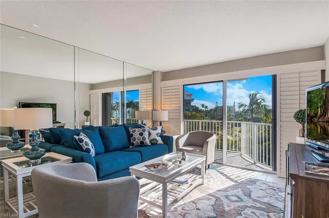 a living room with furniture a flat screen tv and a floor to ceiling window