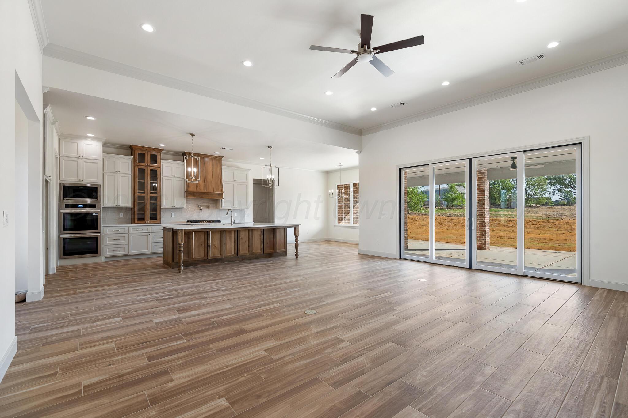 16551 Spring Lake Drive Canyon, TX 79015 - Photo 21 of 60 an empty room with wooden floor and windows
