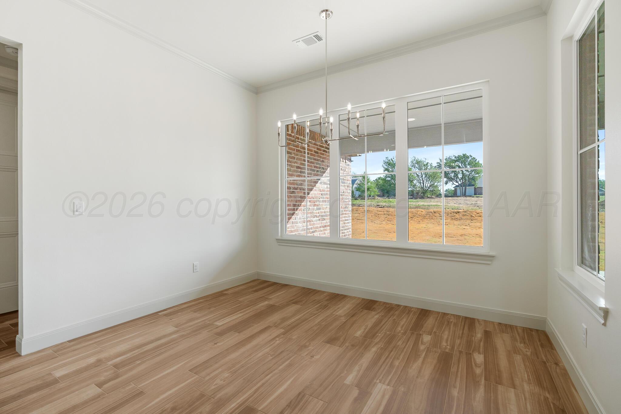 16551 Spring Lake Drive Canyon, TX 79015 - Photo 23 of 60 an empty room with wooden floor and windows